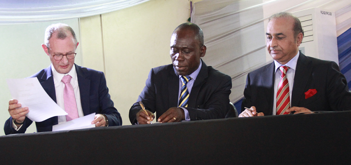 Apostle Dr Daniel O. Walker (middle) appending his signature to the documents, while Prof. Mike Molan (left) and Mr Lone Munir wait to do same